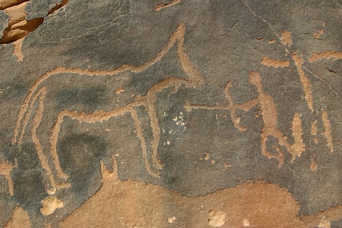 Cave wall drawing of Paleolithic Hunters with spears