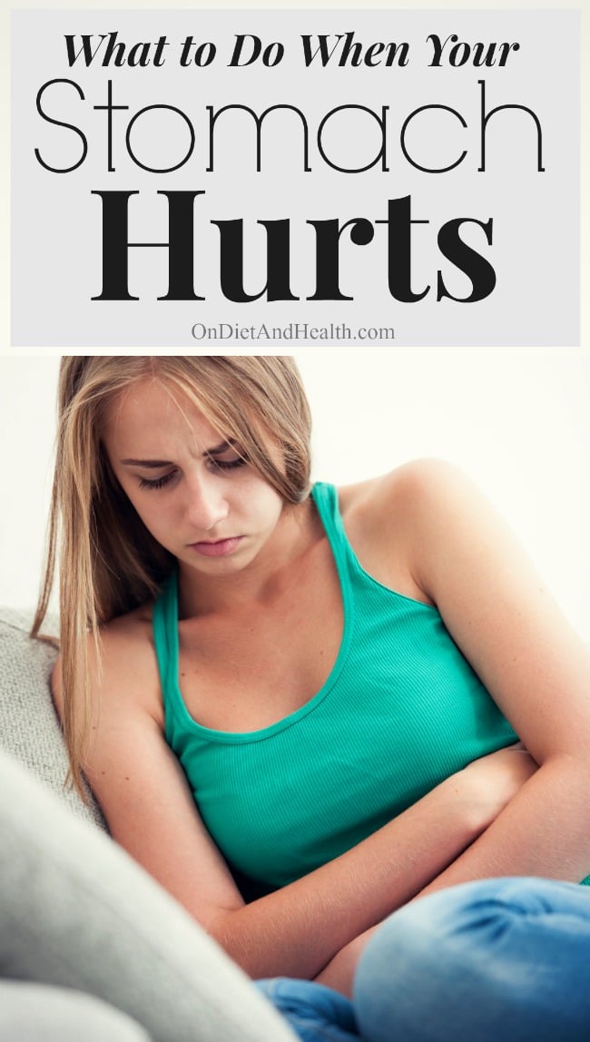young woman holding her stomach possibly in pain